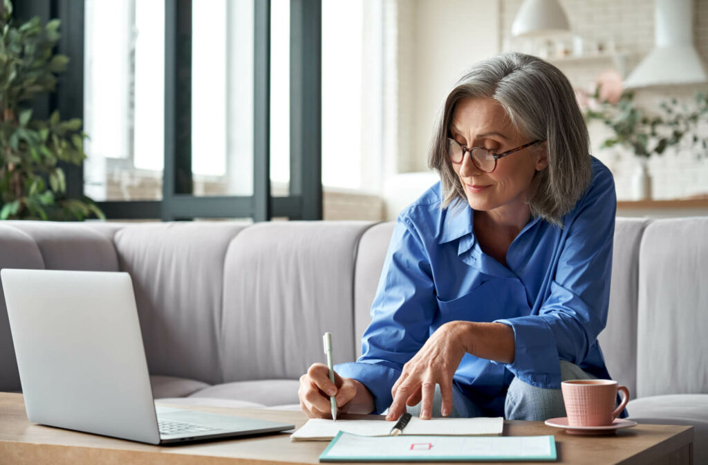 An older adult taking notes and plotting in their day planner to maintain a consistent routine.