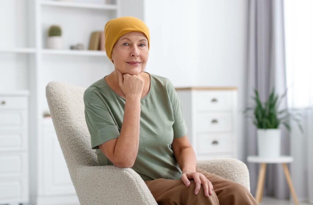 Person wearing a headscarf sitting in a cozy chair and smiling calmly