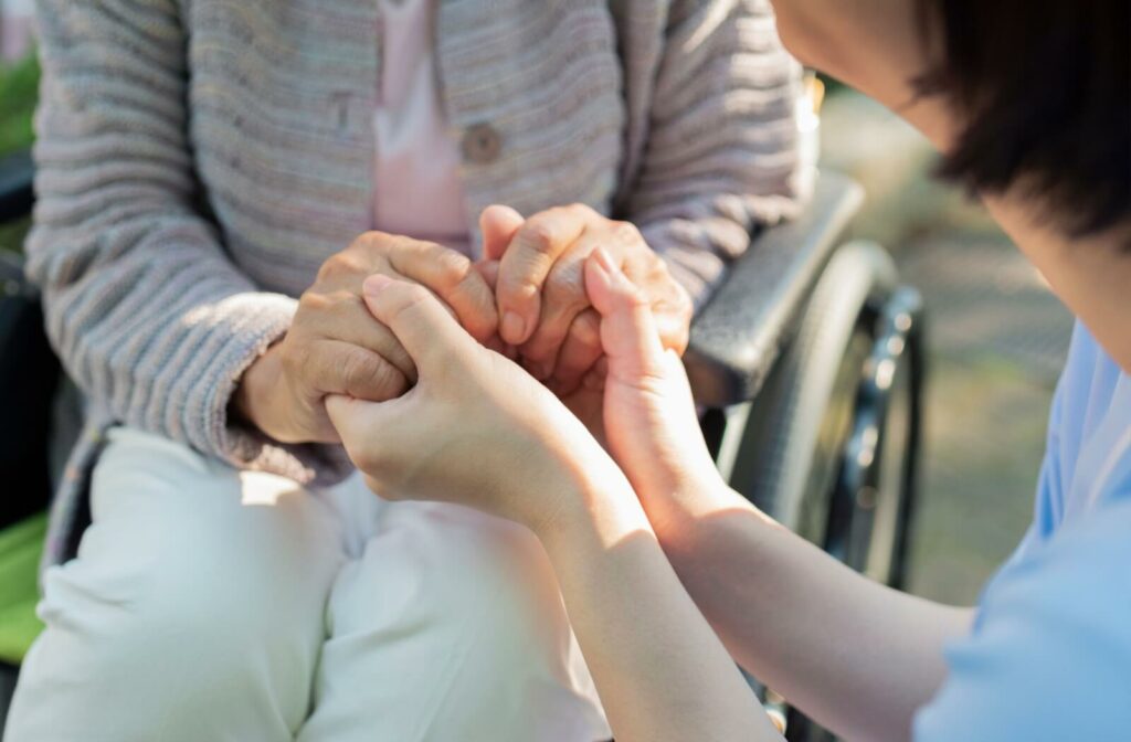 Someone holds the hands of a caregiver, getting support at their memory ca