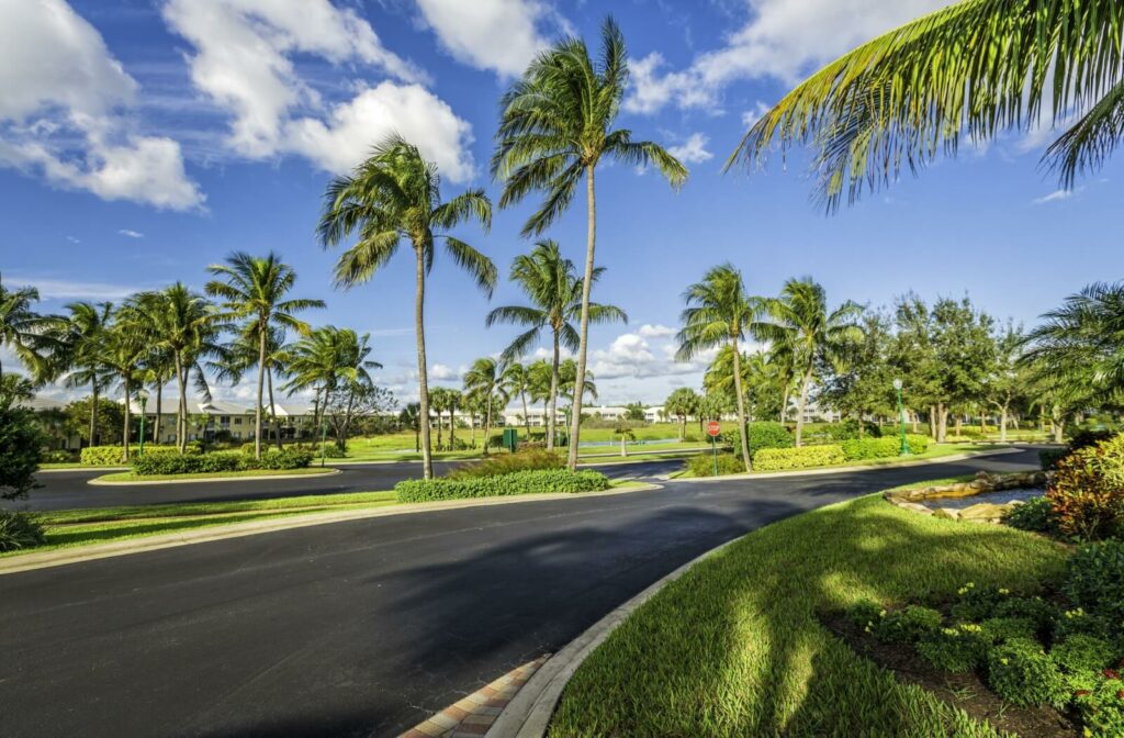 A beautiful community sits nestled in amongst Florida's palm trees, lush grass and clear sky.